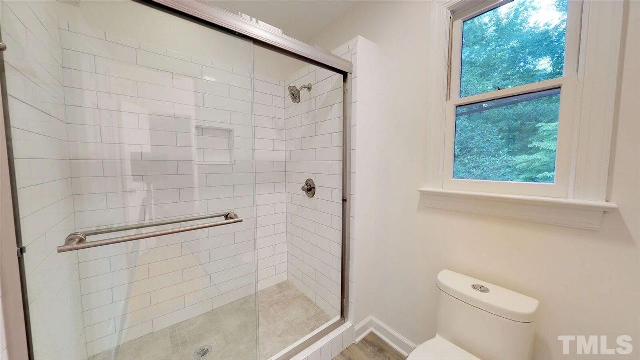5913 Stable Court Raleigh, NC 27612 - Photo 22 of 25 a bathroom with a shower and toilet