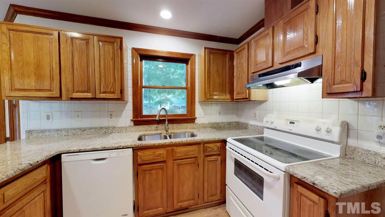 5913 Stable Court Raleigh, NC 27612 - Photo 8 of 25 a kitchen with a sink stove and cabinets