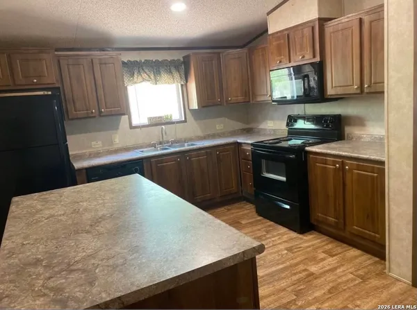 a kitchen with stainless steel appliances granite countertop a sink stove and microwave