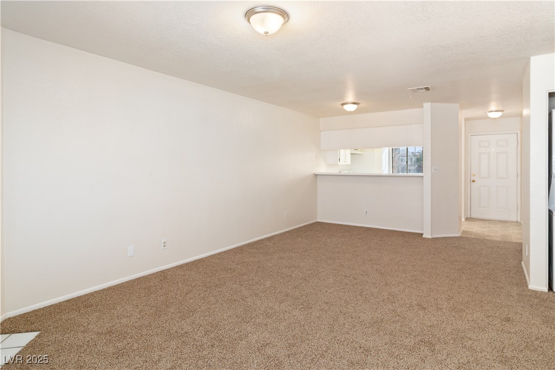2028 Mesquite Lane, Unit 302 Laughlin, NV 89029 - Photo 14 of 60 living room and dining area featuring carpet floors and baseboards