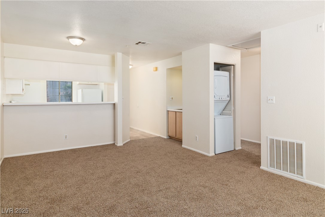 2028 Mesquite Lane, Unit 302 Laughlin, NV 89029 - Photo 15 of 60 Carpeted Dining area with stacked washer / drying machine and baseboards