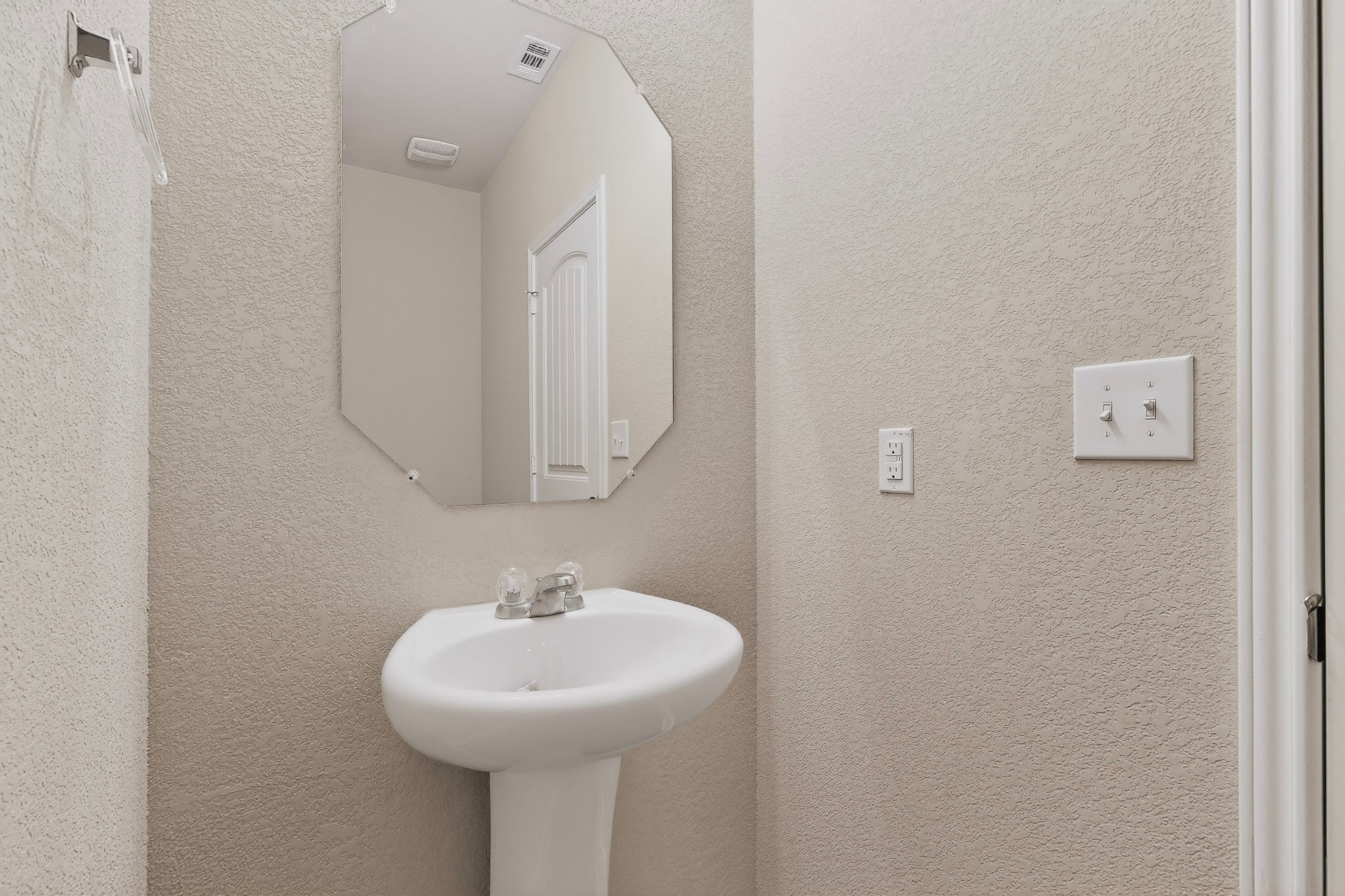 5905 Diamondleaf Bend Austin, TX 78724 - Photo 22 of 38 Pedestal sink with chrome faucet, complemented by an octagonal mirror
