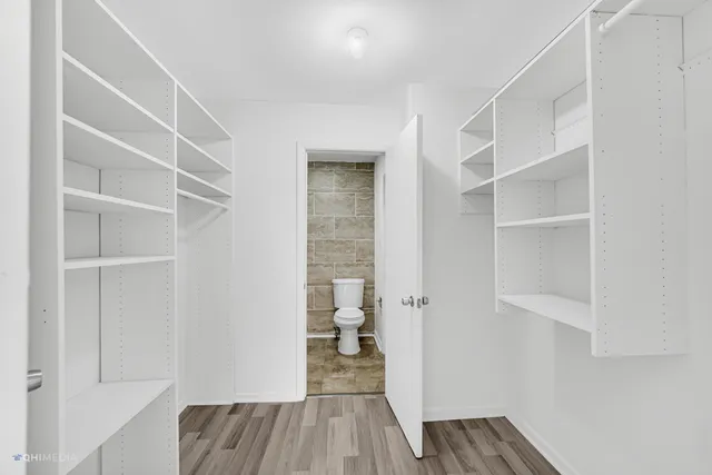 a view of walk in closet with empty racks