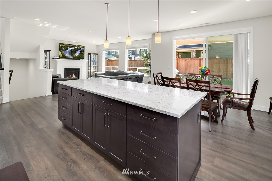 1426 184th Place Southeast Bothell, WA 98012 - Photo 11 of 36 a kitchen with granite countertop a stove a sink a dining table and chairs
