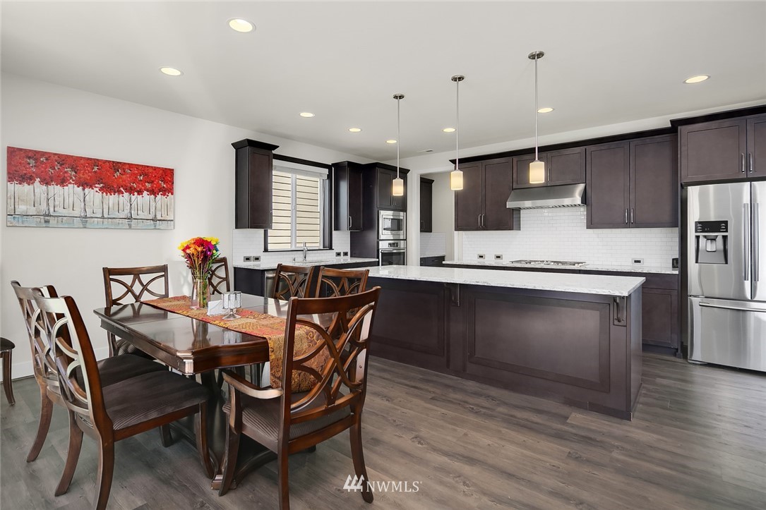 1426 184th Place Southeast Bothell, WA 98012 - Photo 7 of 36 a kitchen with stainless steel appliances granite countertop a kitchen island hardwood floor sink and stove