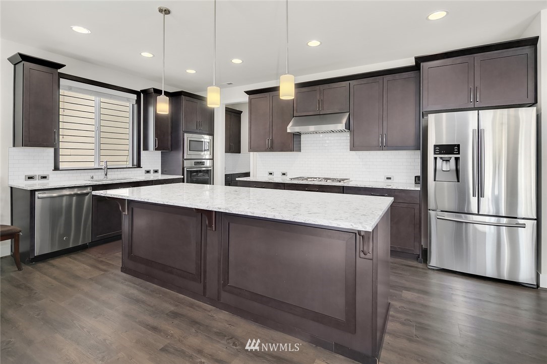 1426 184th Place Southeast Bothell, WA 98012 - Photo 8 of 36 a kitchen with stainless steel appliances a sink a stove a refrigerator and cabinets