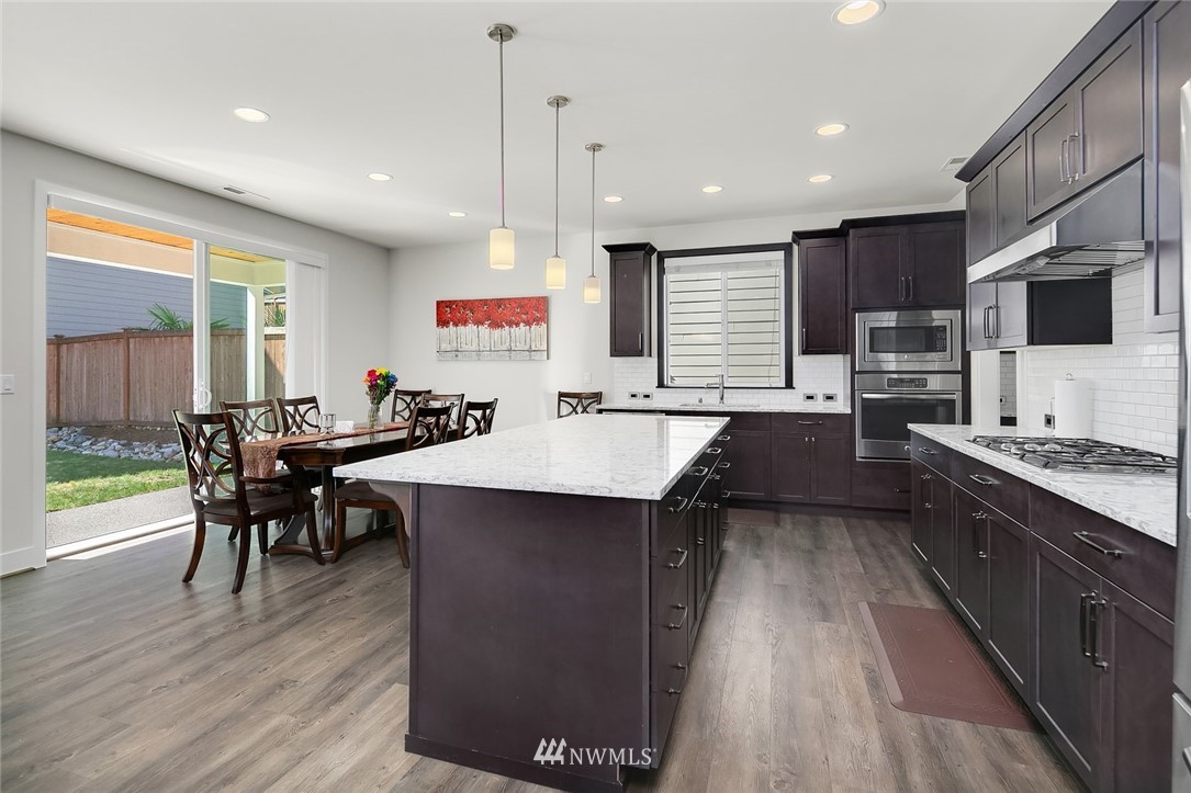 1426 184th Place Southeast Bothell, WA 98012 - Photo 9 of 36 a kitchen with counter space dining table and chairs