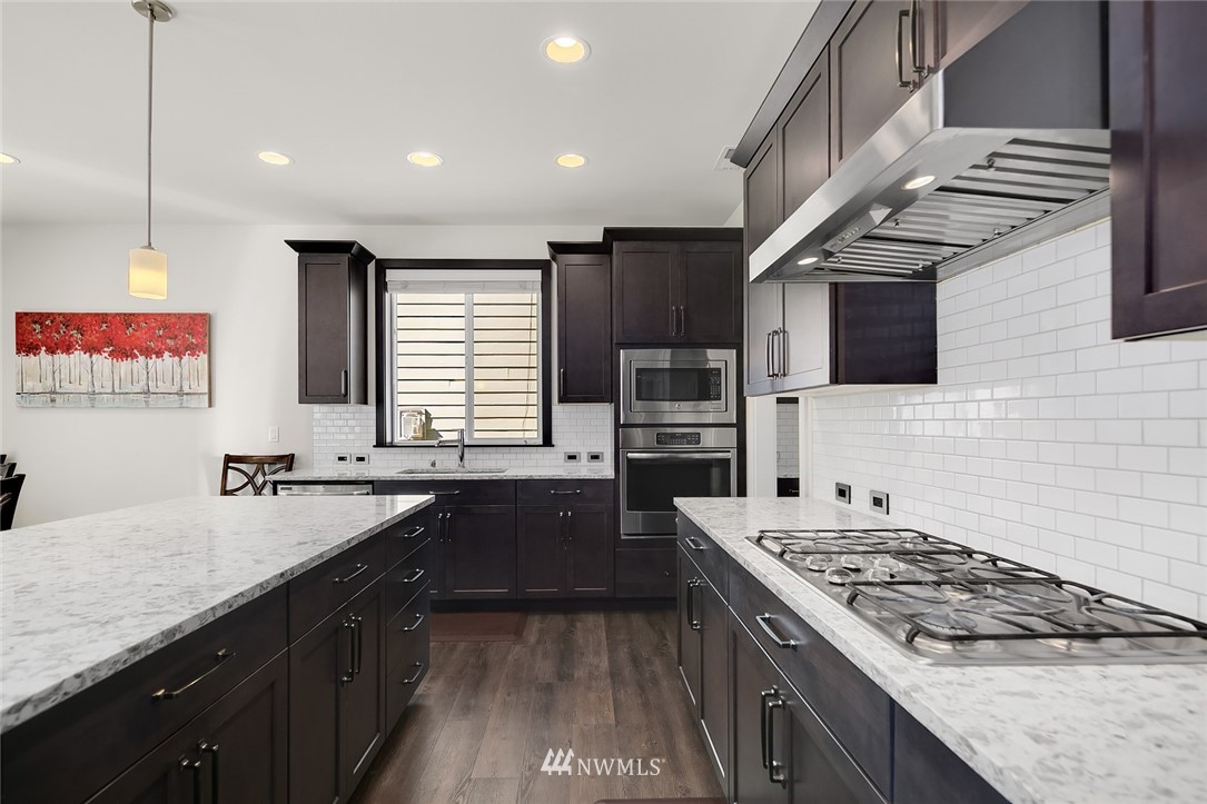 1426 184th Place Southeast Bothell, WA 98012 - Photo 10 of 36 a large kitchen with stainless steel appliances granite countertop a sink stove and refrigerator