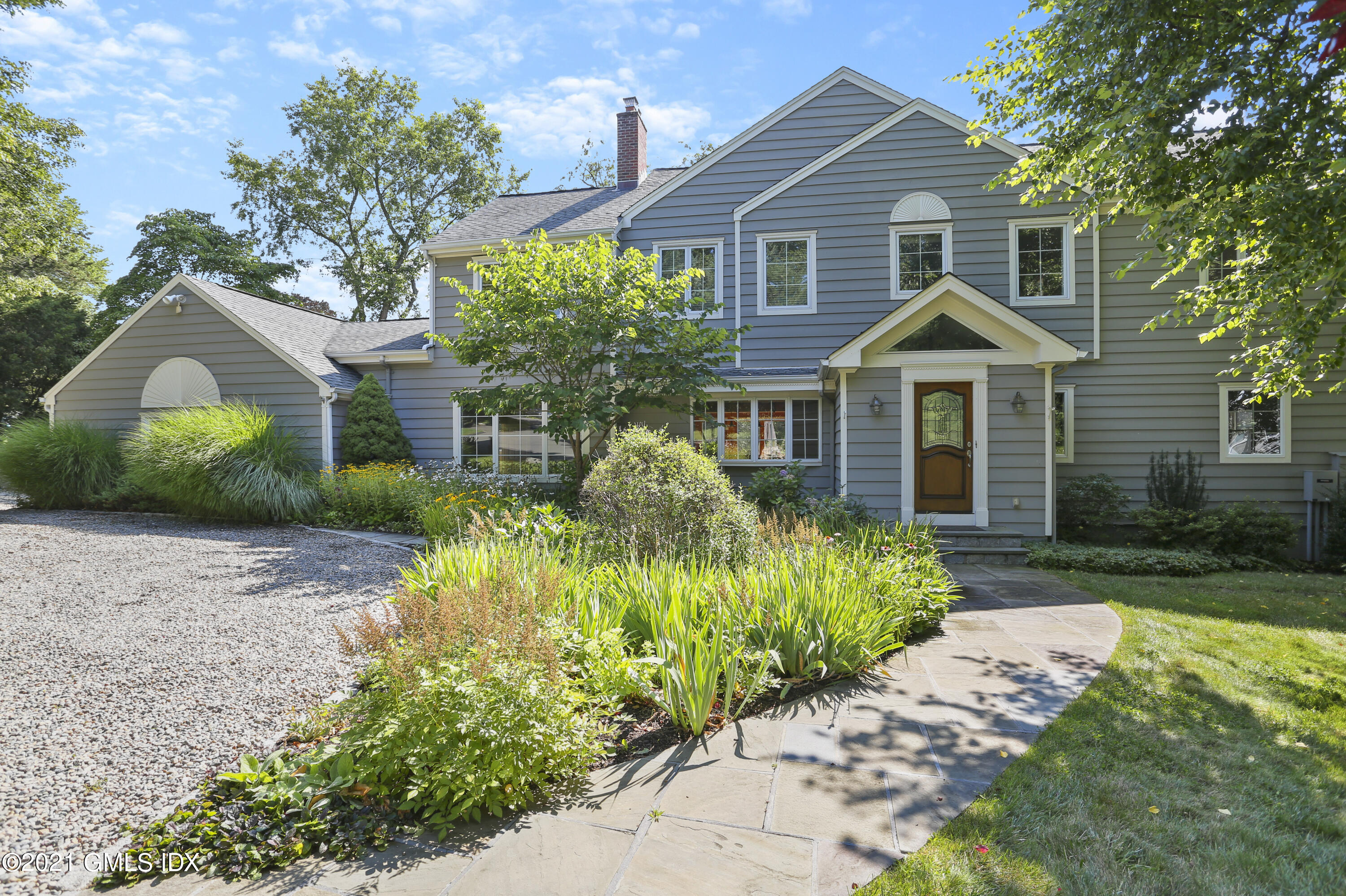 3 Old Wagon Road Old Greenwich, CT 06870 - Photo 1 of 31 a front view of a house with a yard and potted plants