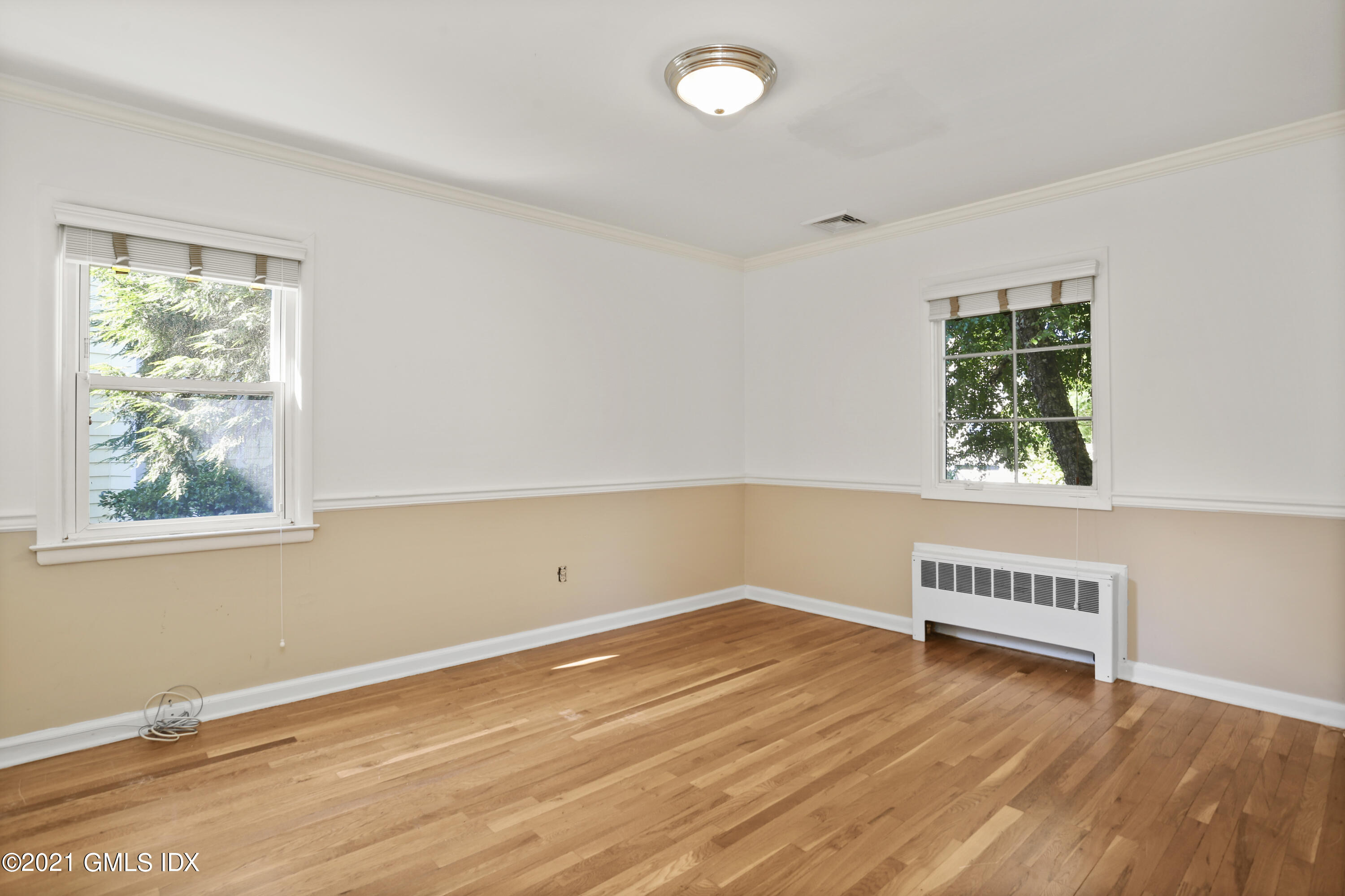 3 Old Wagon Road Old Greenwich, CT 06870 - Photo 14 of 31 an empty room with wooden floor and windows