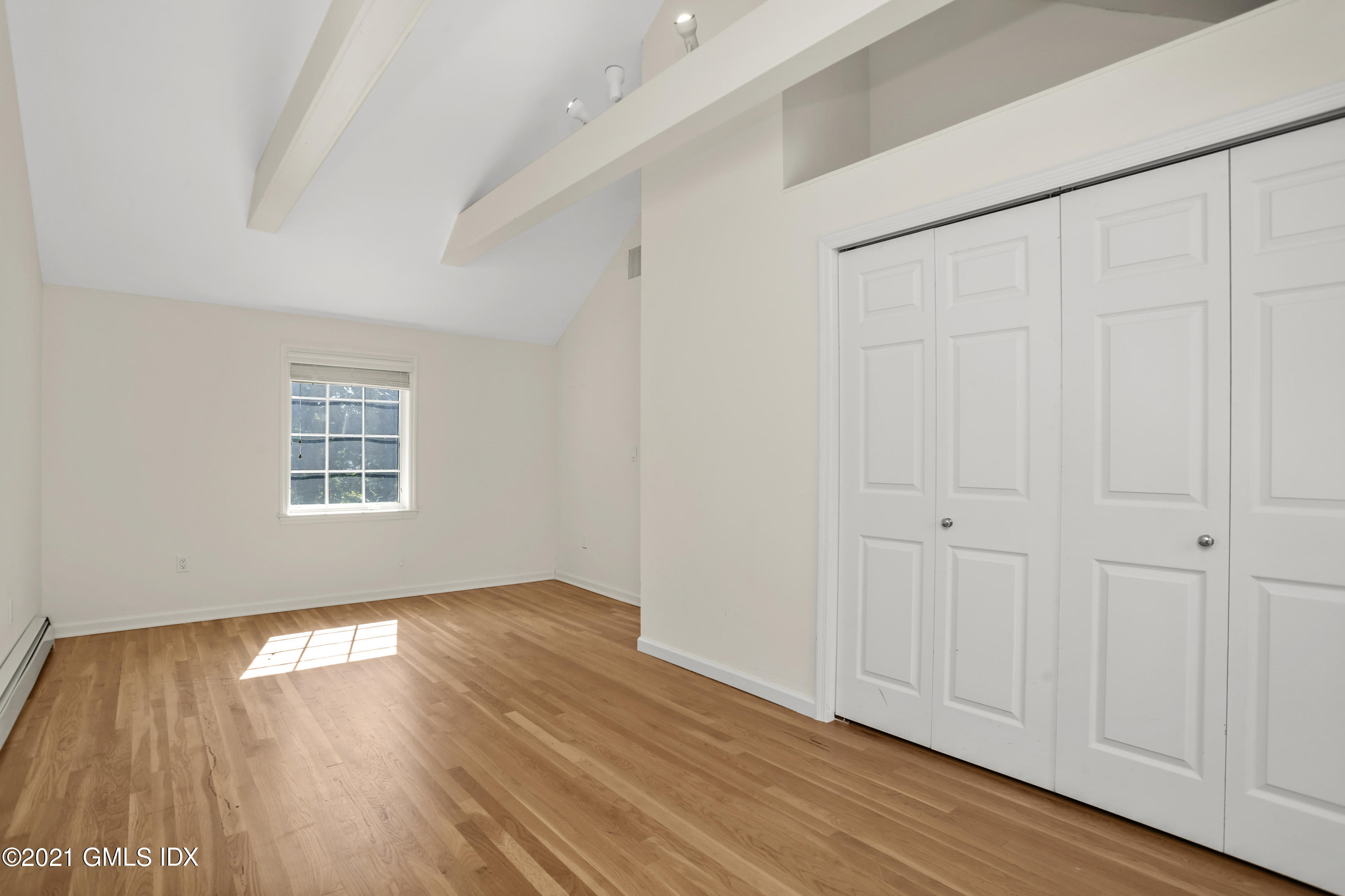 3 Old Wagon Road Old Greenwich, CT 06870 - Photo 22 of 31 a view of an empty room with wooden floor and a window