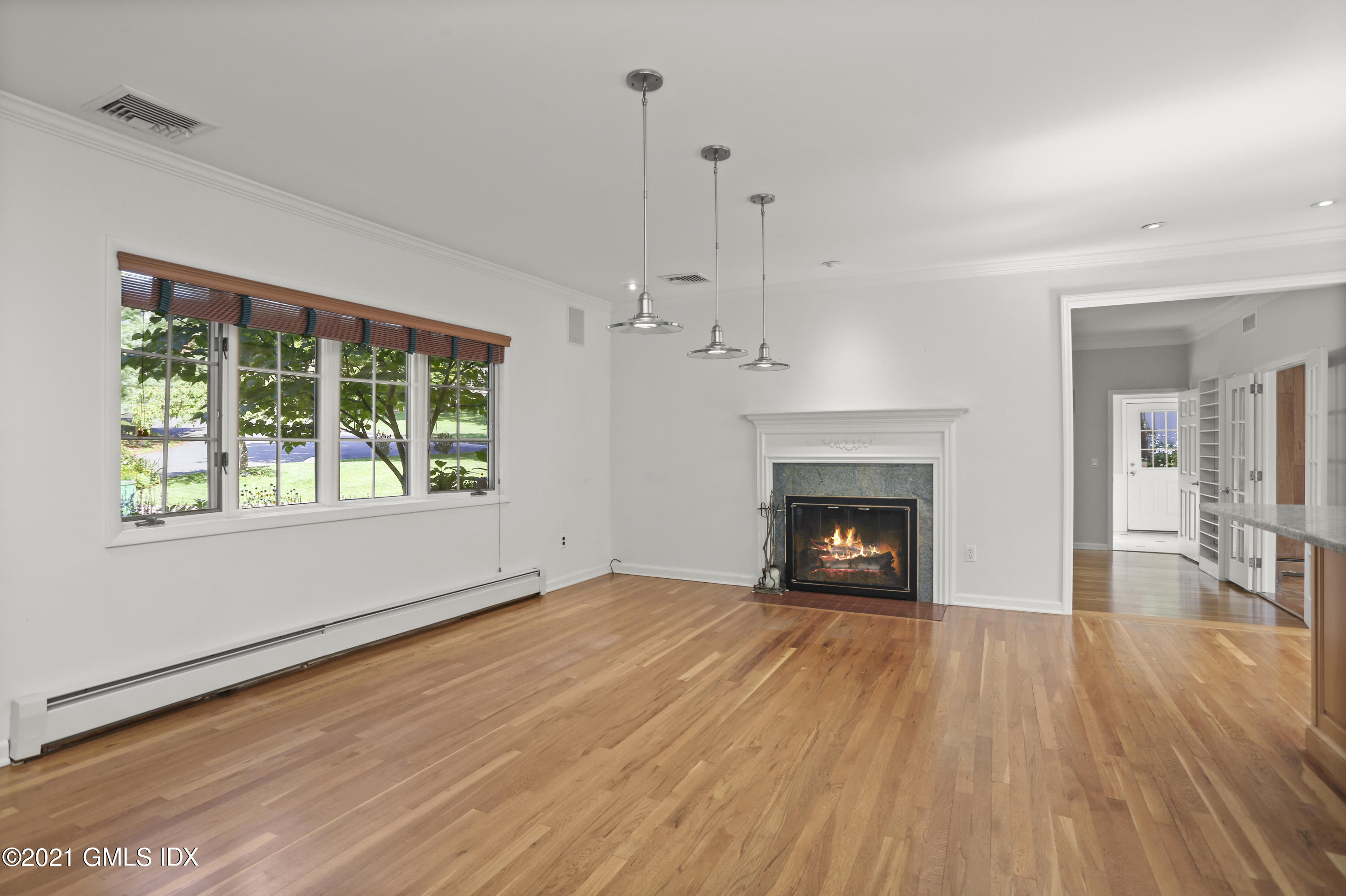 3 Old Wagon Road Old Greenwich, CT 06870 - Photo 5 of 31 a view of an empty room with wooden floor fireplace and a window