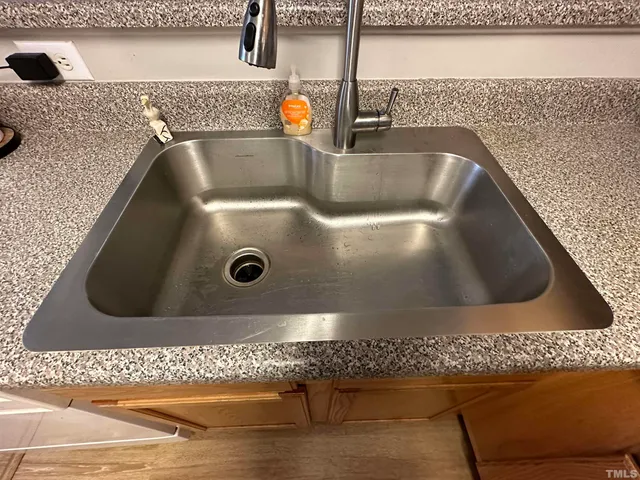 a kitchen with stainless steel appliances granite countertop a sink refrigerator and cabinets