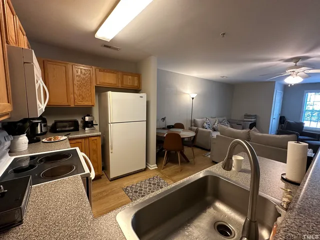 a living room with furniture windows and a refrigerator