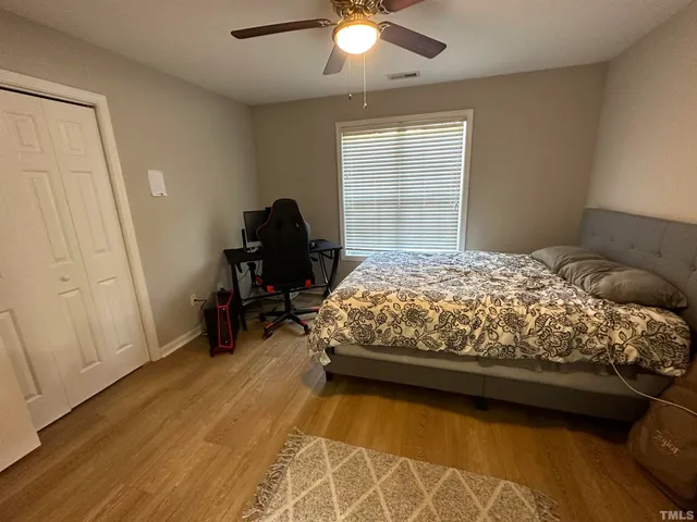 a bedroom with a bed and wooden floor