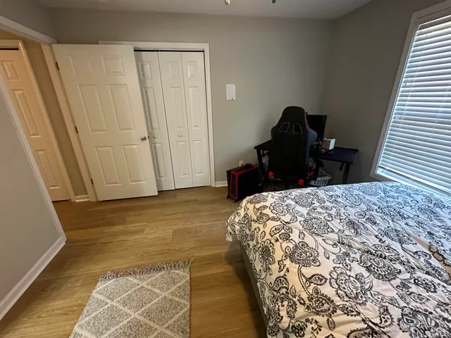 a bedroom with a bed and wooden floor
