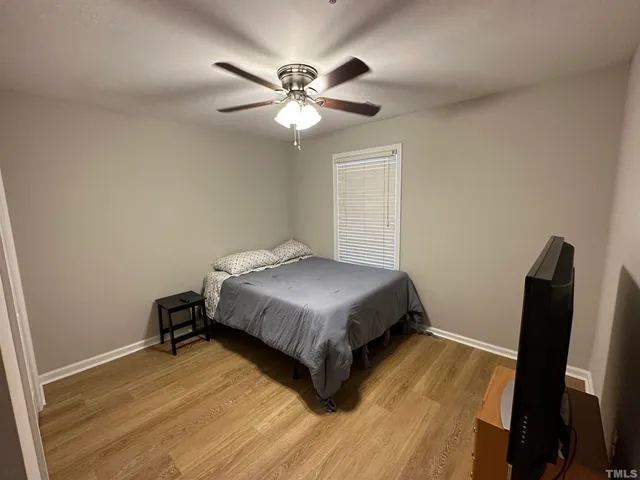 a bedroom with a bed and wooden floor