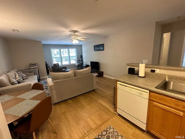 a kitchen with a sink a stove a refrigerator a washer and dryer with wooden floor