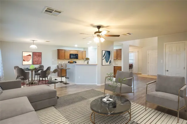a living room with furniture kitchen view and a chandelier