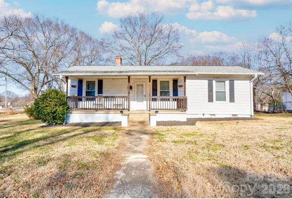 a view of a house with snow on the wall and trees around