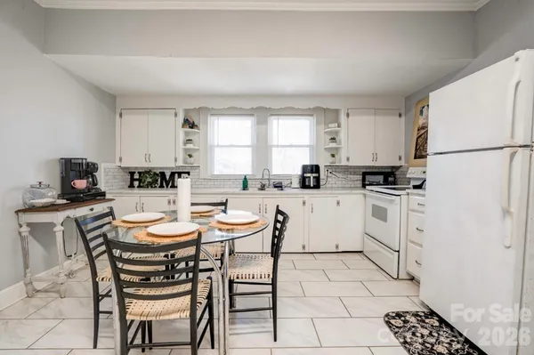 a kitchen with a stove a sink a dining table and chairs