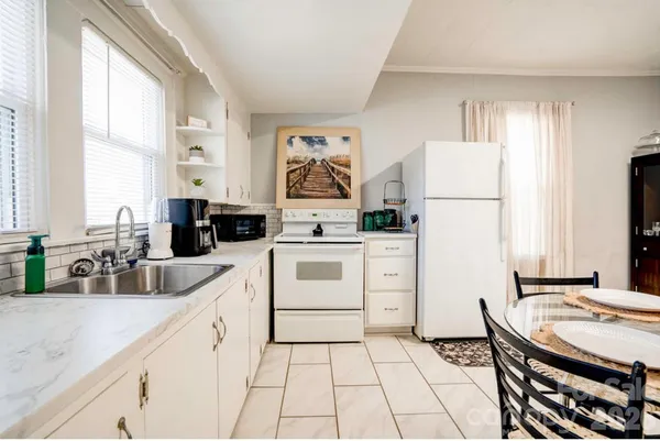 a kitchen with white cabinets and white appliances