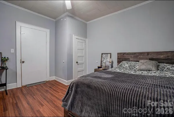 a bedroom with a bed and wooden floor