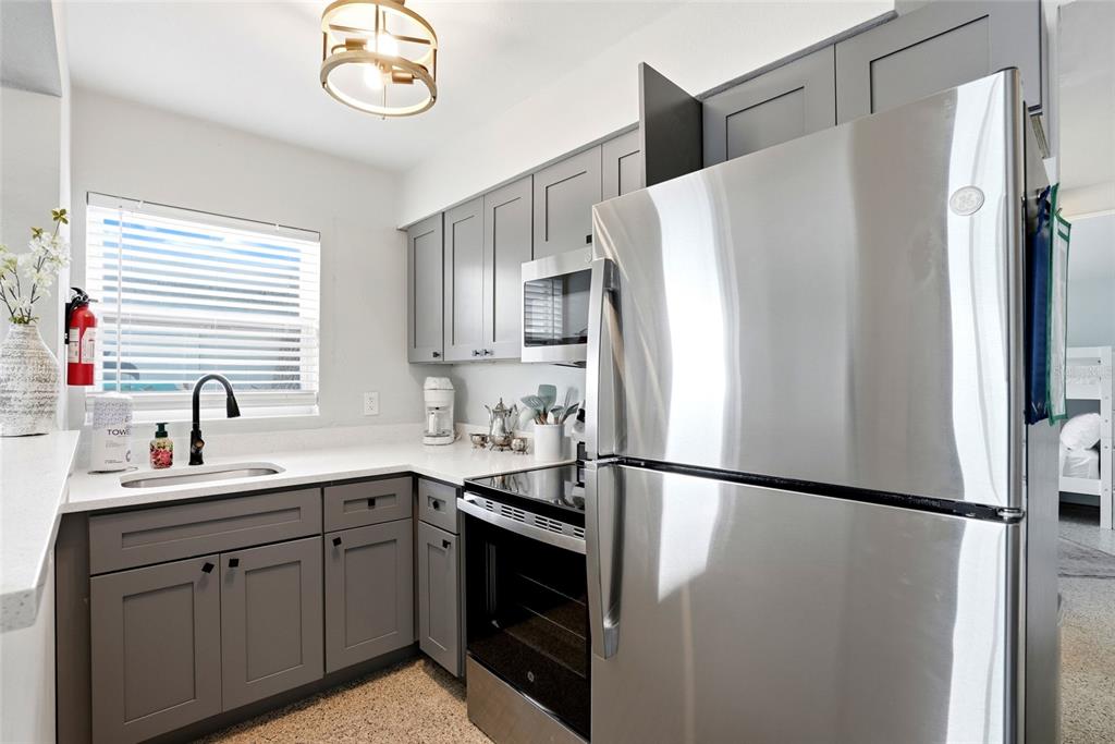 2311 Bay Boulevard Indian Rocks Beach, FL 33785 - Photo 24 of 80 a kitchen with stainless steel appliances a refrigerator sink and cabinets