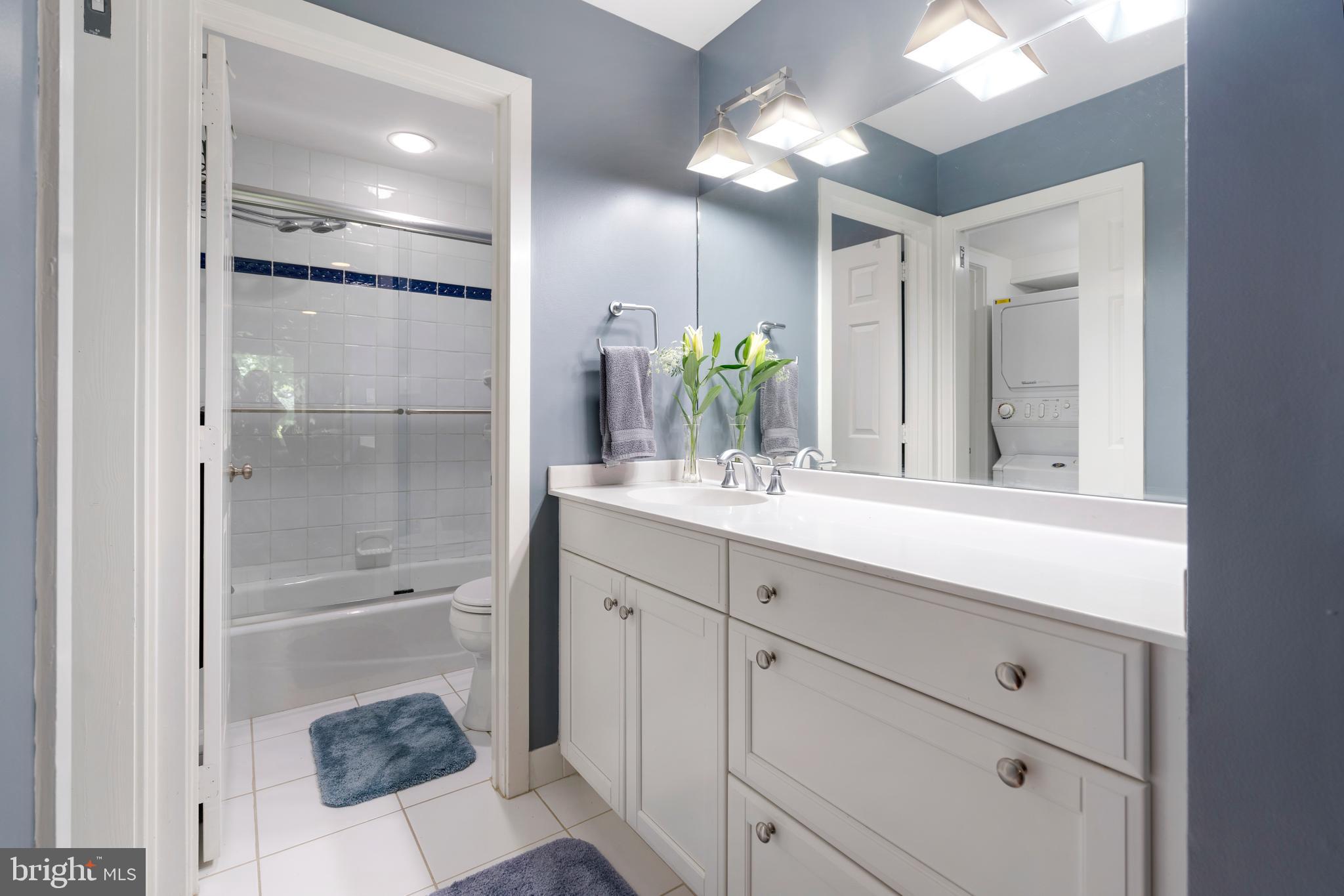 232 Church Road, Unit 3B Ardmore, PA 19003 - Photo 12 of 18 a bathroom with a shower sink vanity and mirror