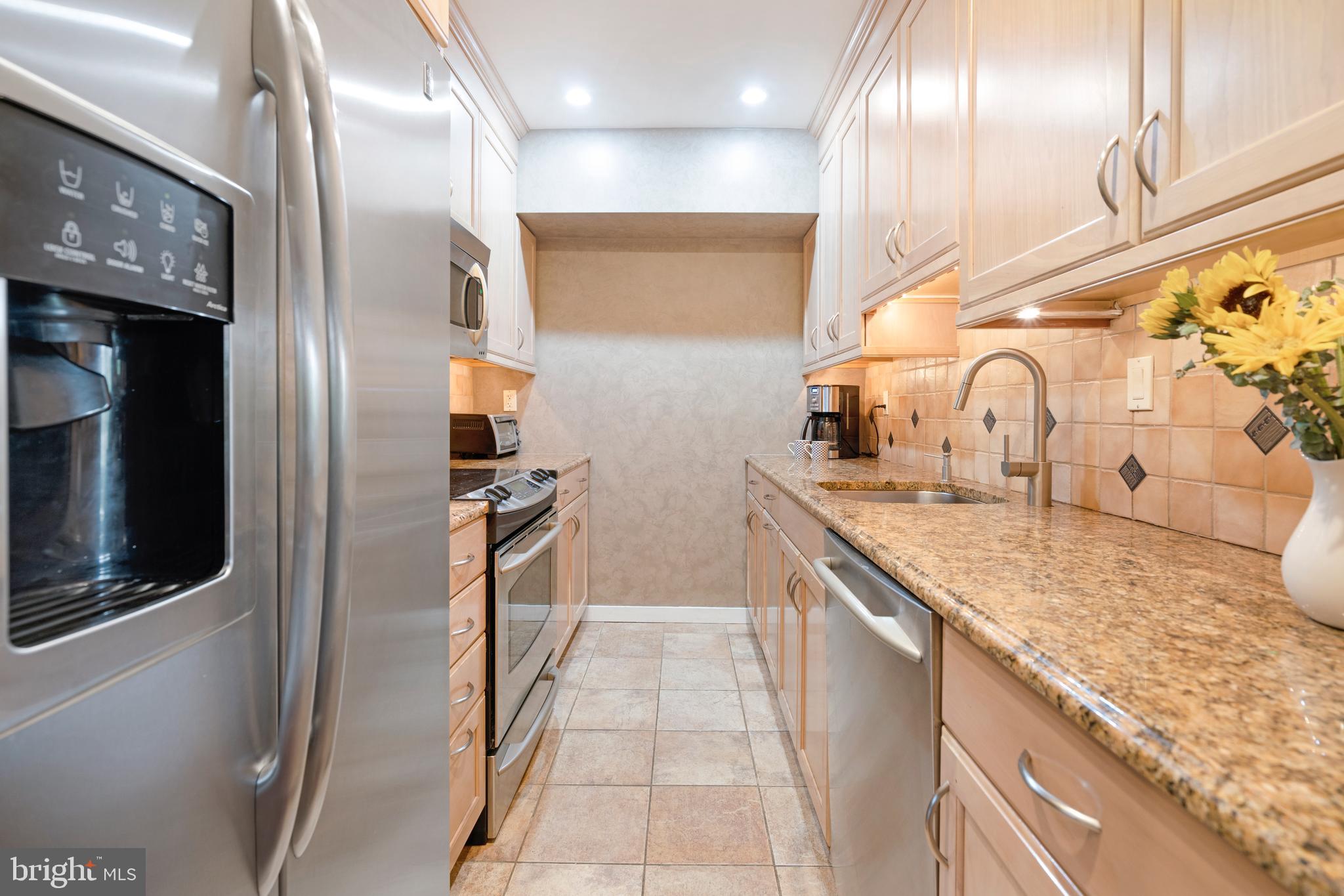 232 Church Road, Unit 3B Ardmore, PA 19003 - Photo 7 of 18 a kitchen with stainless steel appliances granite countertop a sink and a refrigerator