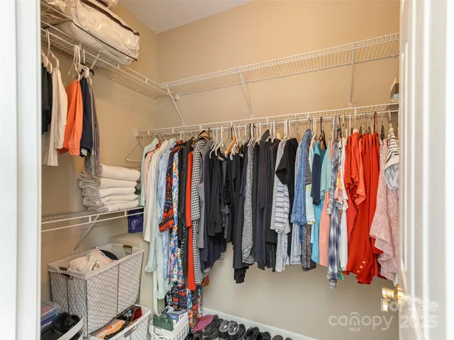 a view of walk in closet with clothes