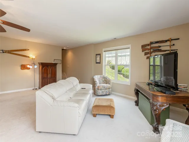 a living room with furniture a flat screen tv and a window