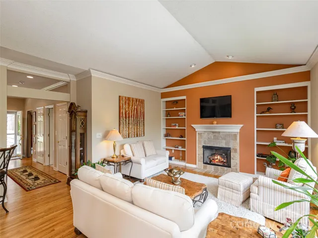 a living room with furniture a fireplace and a flat screen tv