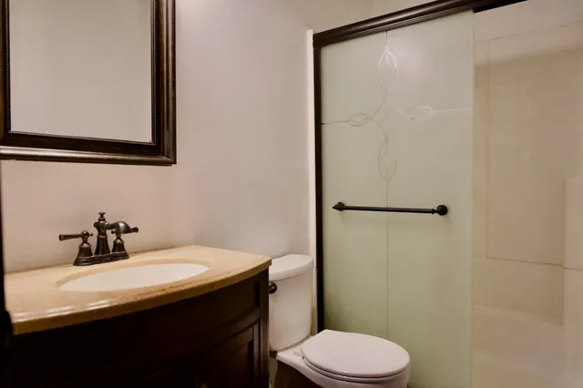 a bathroom with a sink a toilet and shower