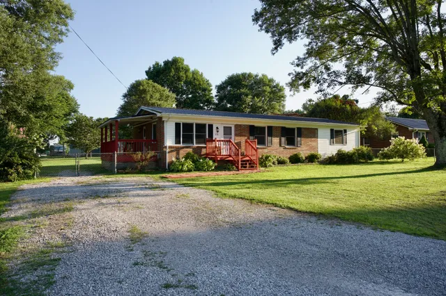a view of a house with a yard table and chairs