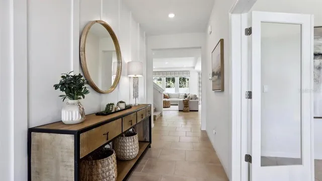 a living room with furniture a mirror and a wooden floor