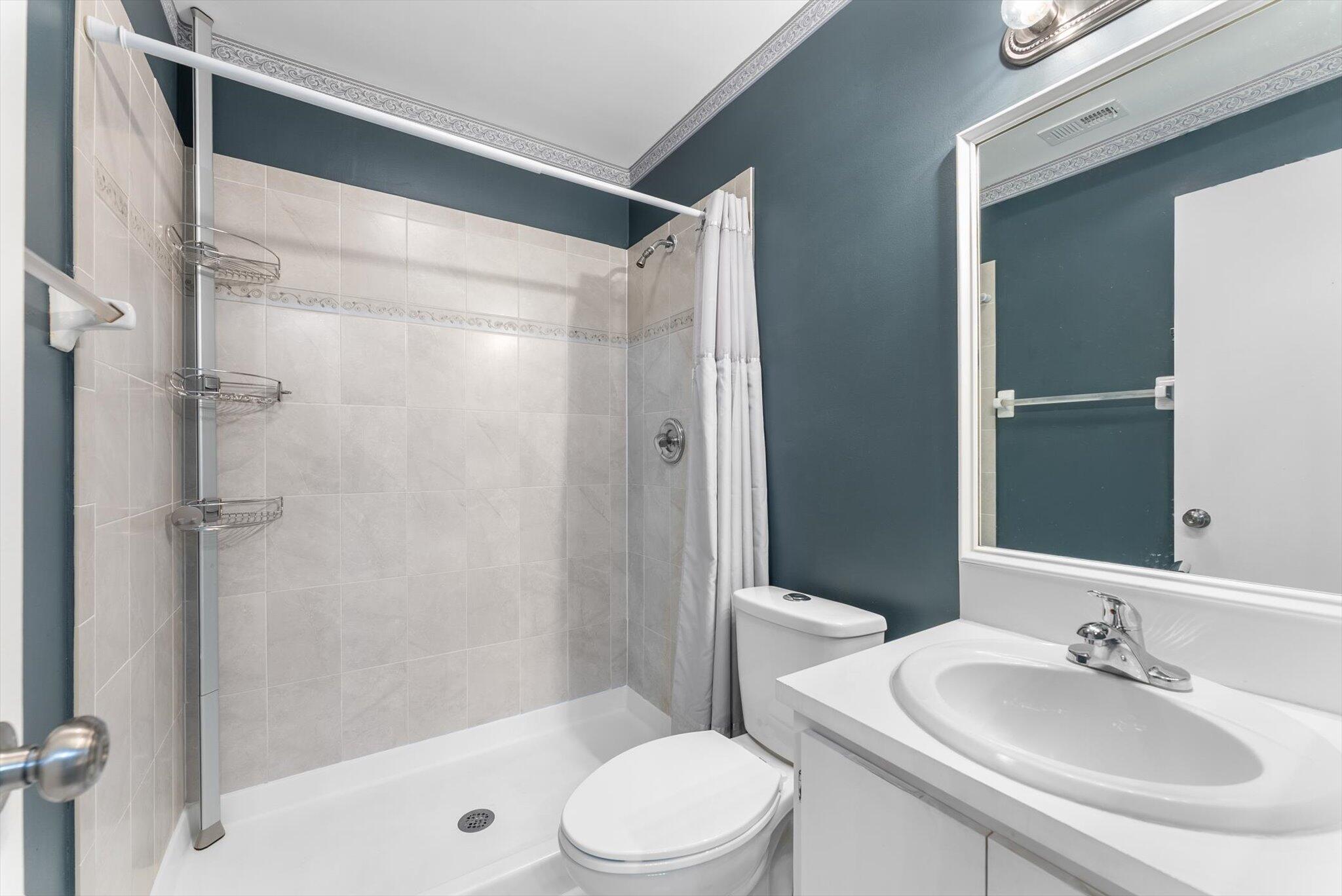 5321 Poppy Place, Unit 203 Delray Beach, FL 33484 - Photo 21 of 31 a bathroom with a sink toilet and shower