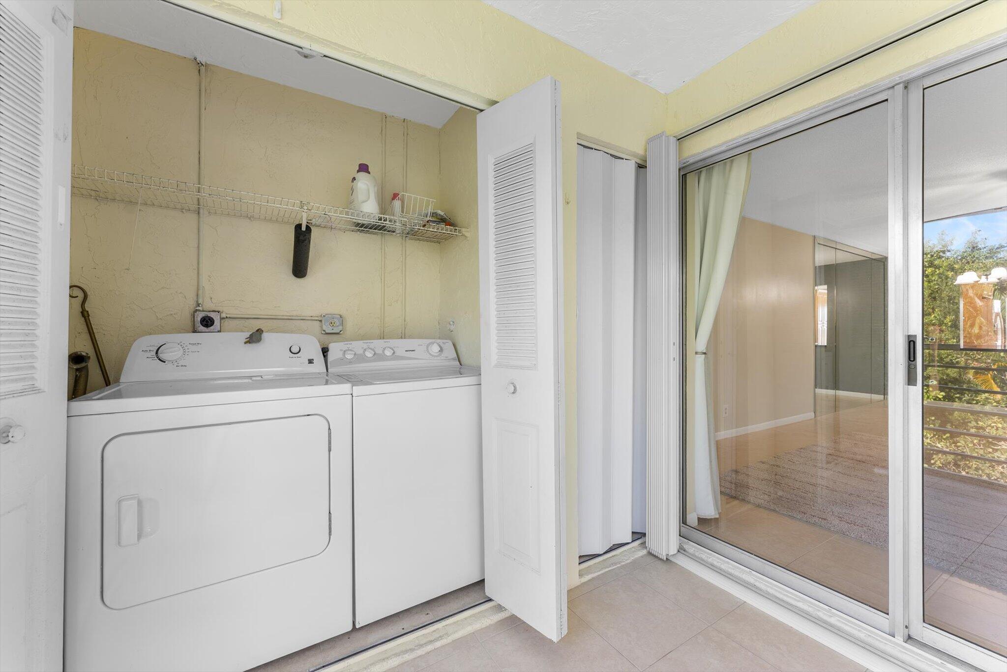 5321 Poppy Place, Unit 203 Delray Beach, FL 33484 - Photo 24 of 31 a utility room with cabinets washer and dryer