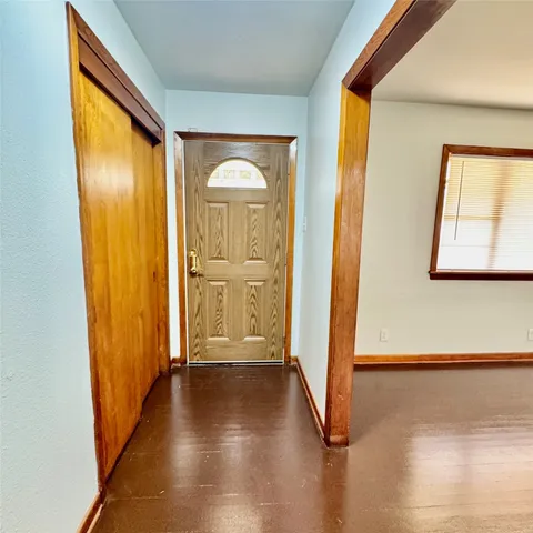 a view of a hallway with wooden floor and windows