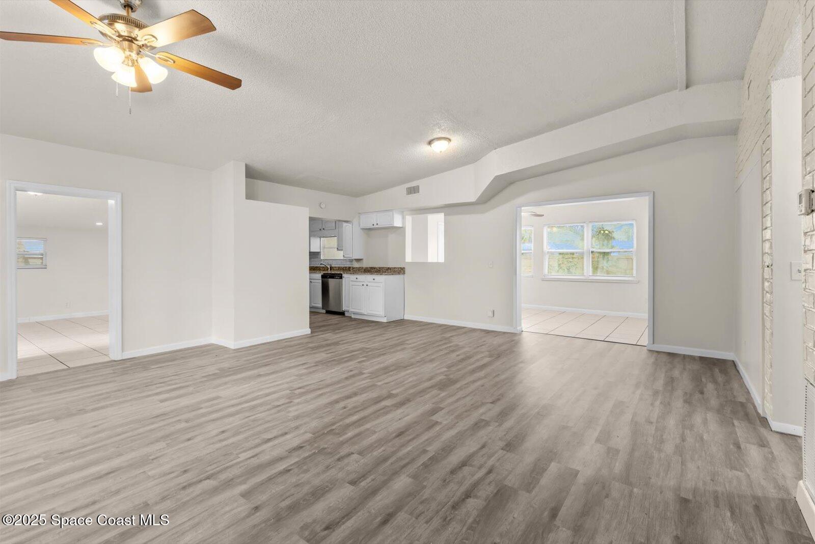 7506 Roberts Road Fort Pierce, FL 34951 - Photo 4 of 33 a view of empty room with wooden floor and fan