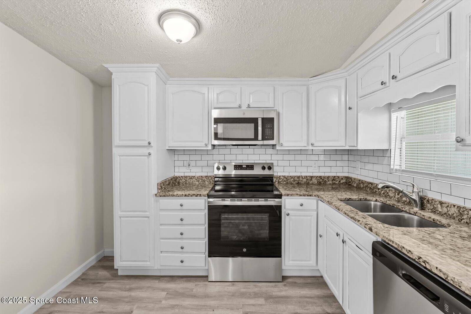 7506 Roberts Road Fort Pierce, FL 34951 - Photo 8 of 33 a kitchen with granite countertop a stove sink and cabinets