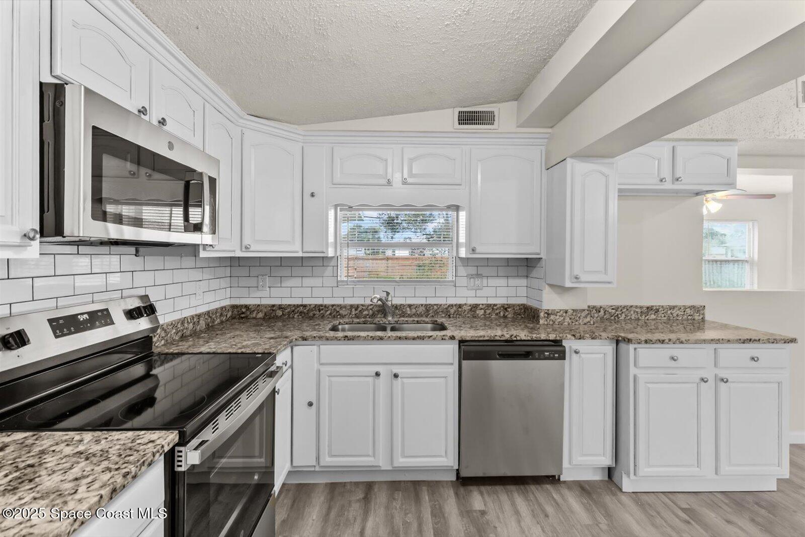 7506 Roberts Road Fort Pierce, FL 34951 - Photo 9 of 33 a kitchen with granite countertop a stove sink and microwave