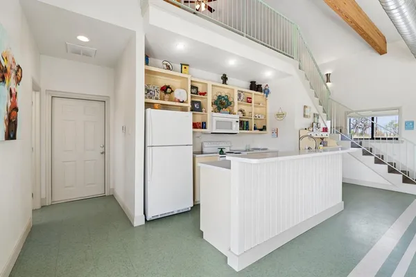 a view of kitchen with stainless steel appliances refrigerator stove microwave and cabinets