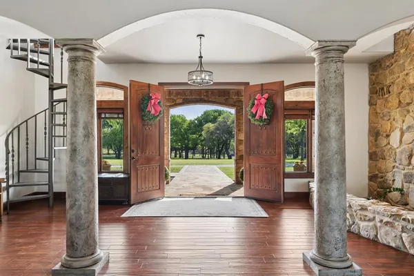 a view of a hallway with wooden floor and windows