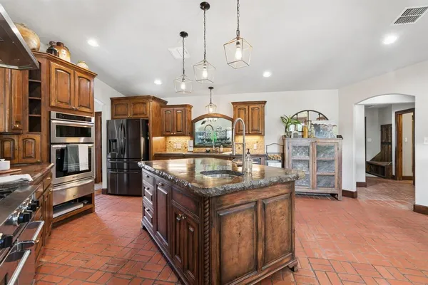 a kitchen with stainless steel appliances granite countertop a stove and cabinets