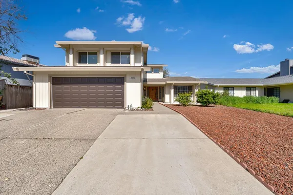 a front view of a house with a yard and a garage