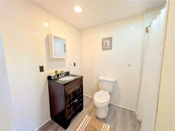 a bathroom with a granite countertop toilet and a sink