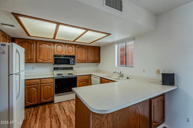 a kitchen with stainless steel appliances a sink a stove a refrigerator and cabinets
