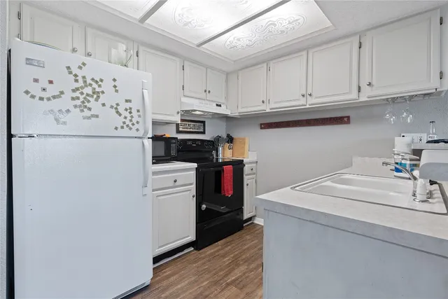 a kitchen with white cabinets and white appliances