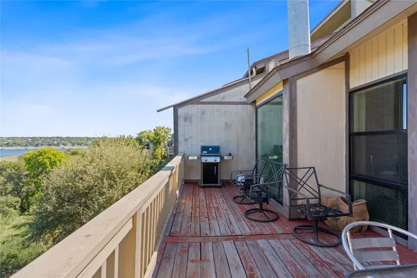 a view of a balcony with chairs and wooden floor